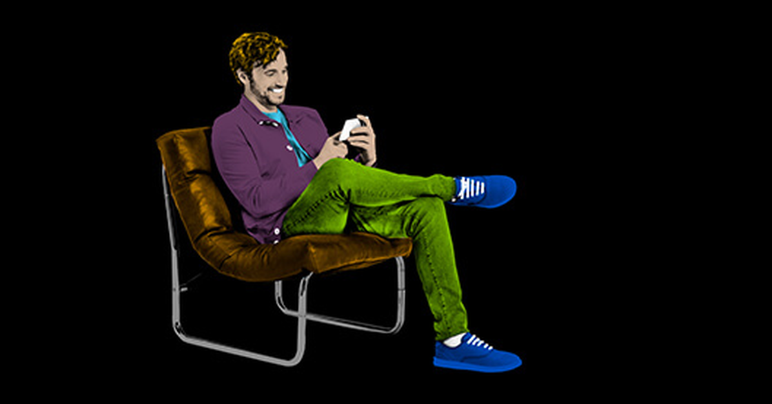 Farbenfroher Mann im Retro-Sessel mit Smartphone
