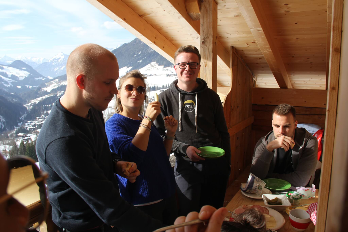 Gemütliche Berghüttenterrasse mit Freunden, Alpenblick und gemeinsamem Essen