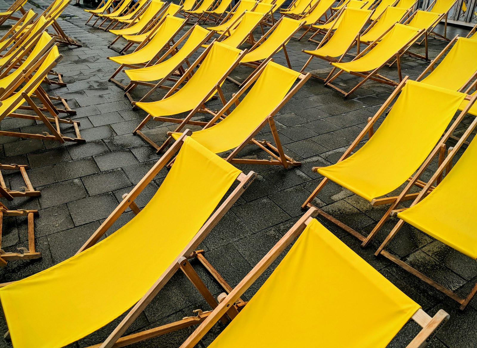 Viele Reihen gelber Liegestühle
