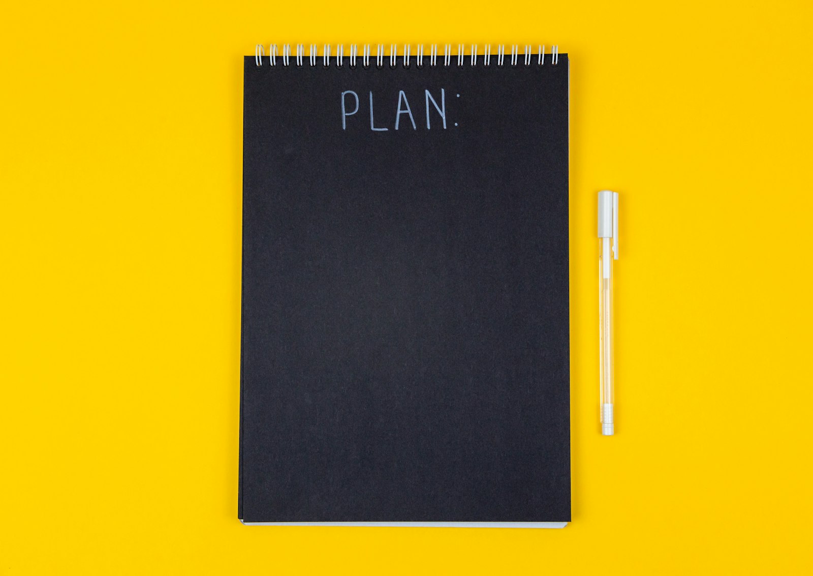 Notizbuch mit der Aufschrift Plan auf gelbem Grund
