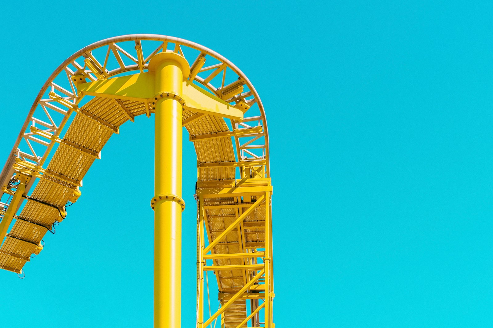 Gelbe Achterbahnschiene vor blauem Himmel