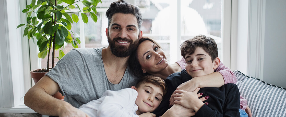 Glückliche Familie sitzt entspannt auf dem Sofa im Wohnzimmer