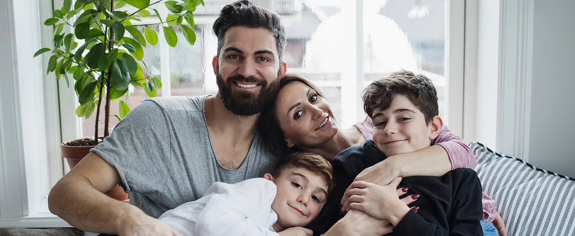 Glückliche Familie sitzt entspannt auf dem Sofa im Wohnzimmer