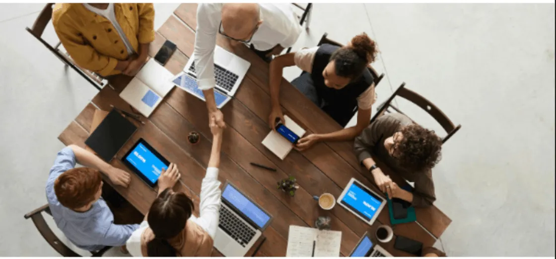 Teammeeting mit Laptops und Tablets am Konferenztisch