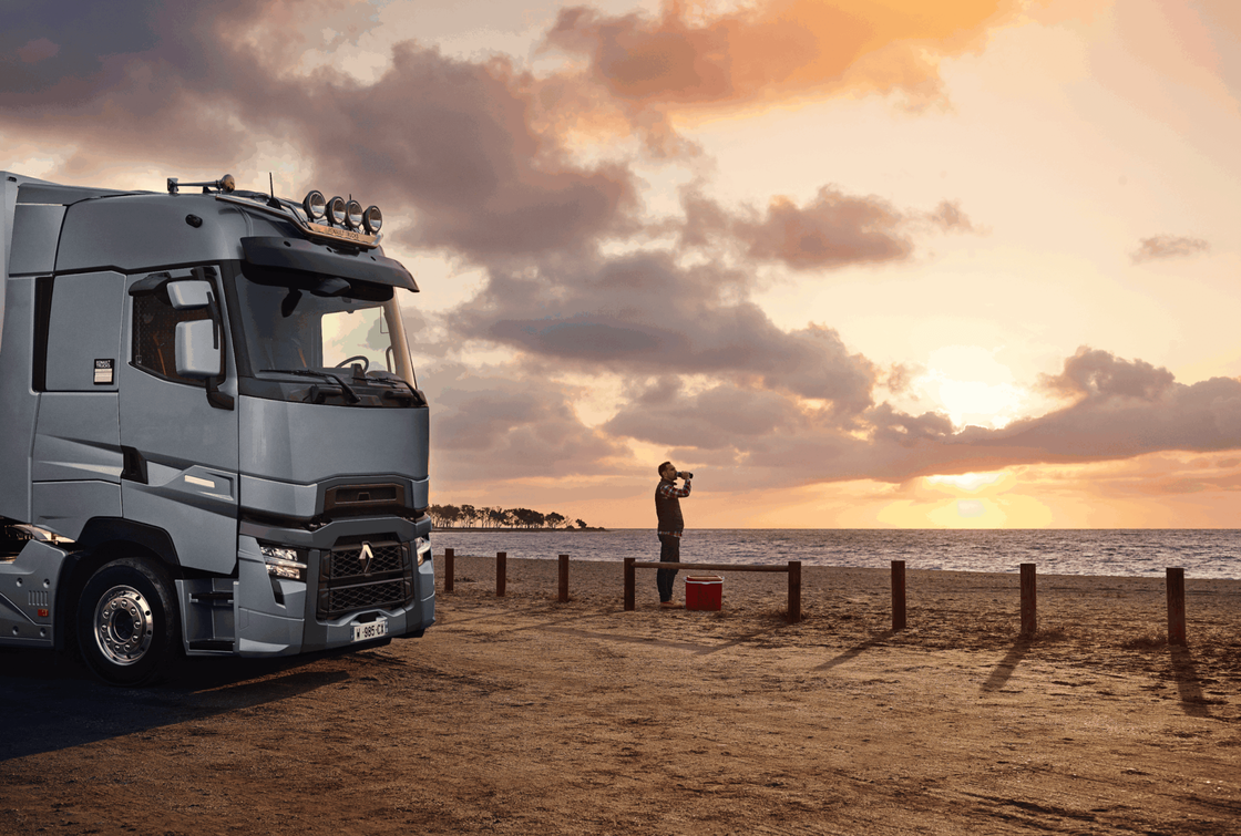 Parkender Lkw am Strand bei Sonnenuntergang, Person beobachtet das Meer
