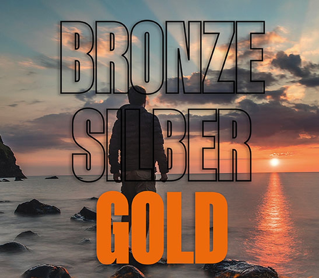 Statusstufen Bronze, Silber und Gold über einer Silhouette am Meer bei Sonnenuntergang