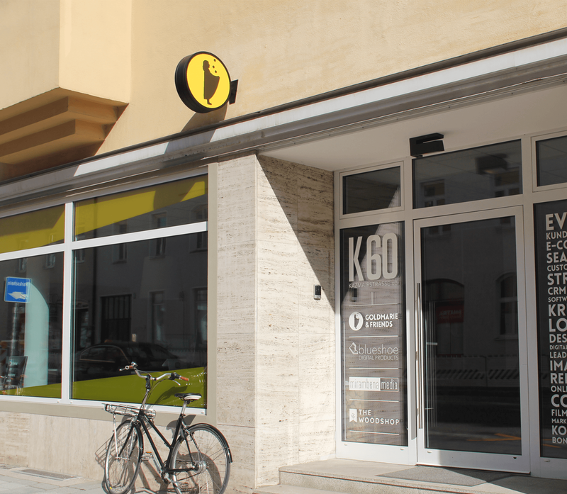 Modernes K80-Ladenlokal mit Glasfassade und gelbem Logo