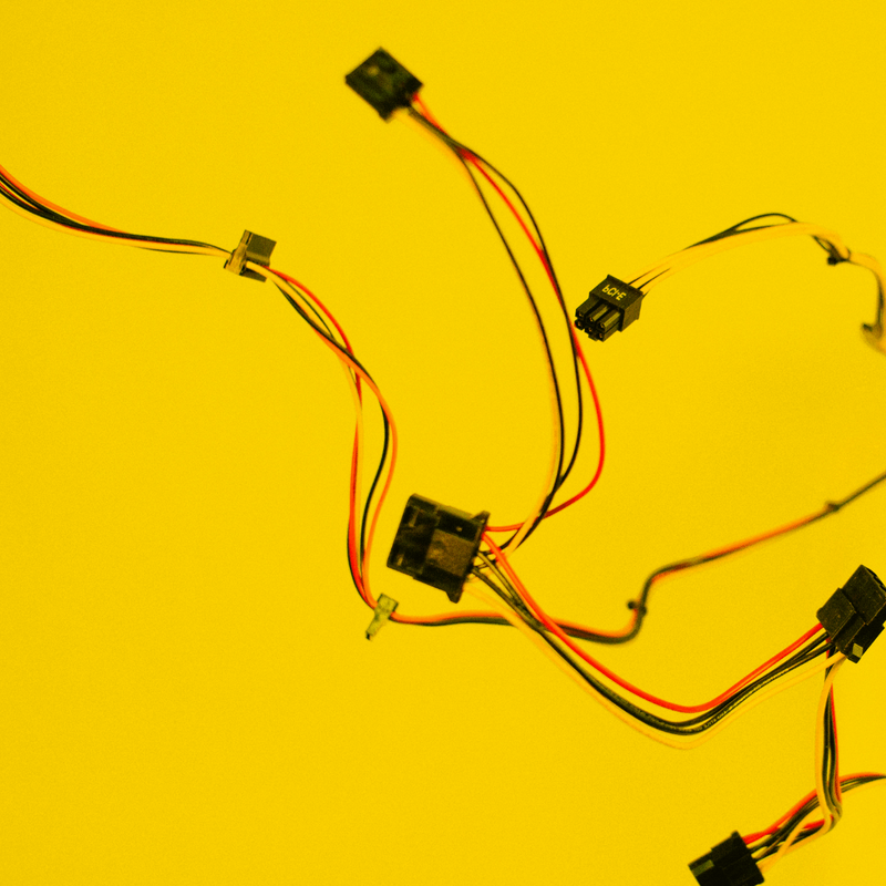 Bunte Kabel mit Steckverbindern verstreut auf gelbem Hintergrund