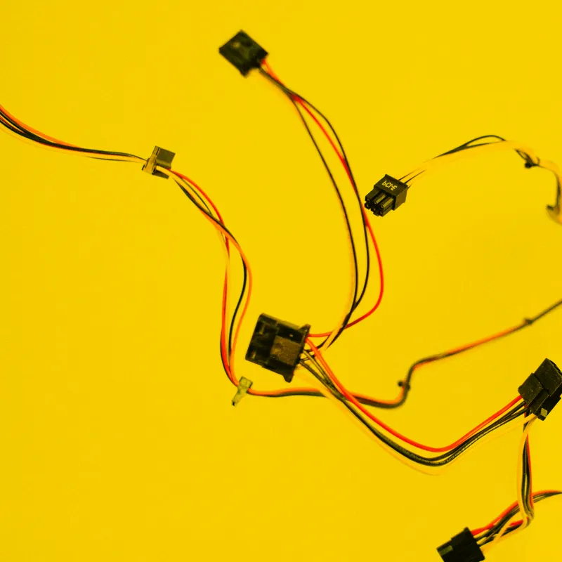 Bunte Kabel mit Steckverbindern verstreut auf gelbem Hintergrund