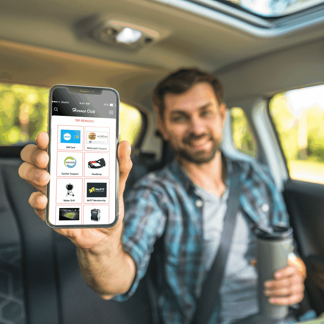 Mann zeigt Smartphone mit Vorteilsprogramm für Lkw‑Fahrer im Auto