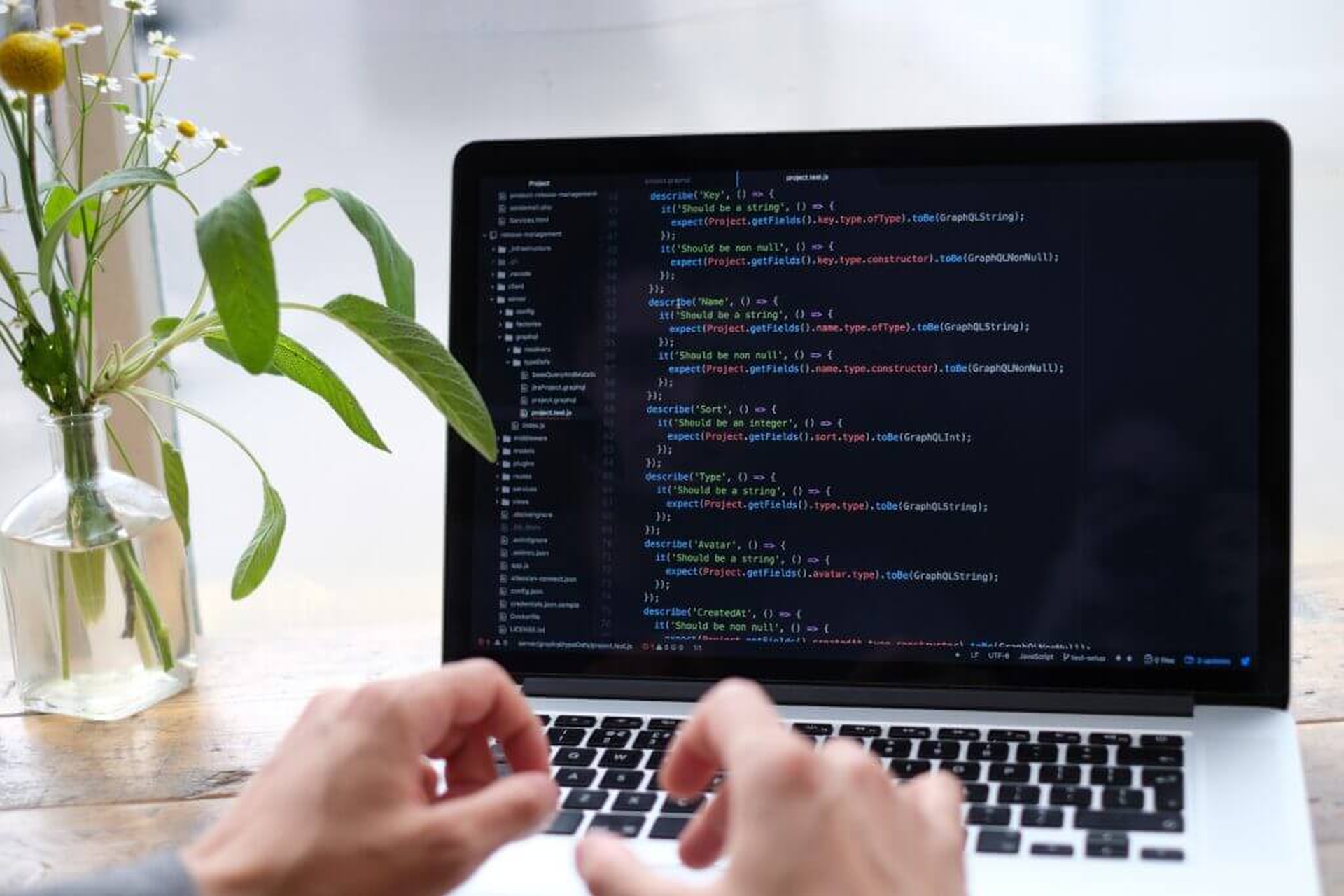 Hände tippen Programmcode auf einem Laptop