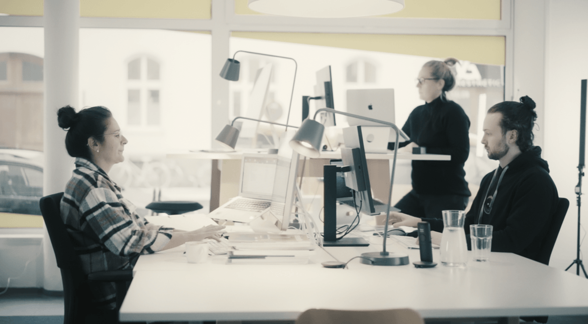 Team arbeitet an Bildschirmen in einem hellen Büro