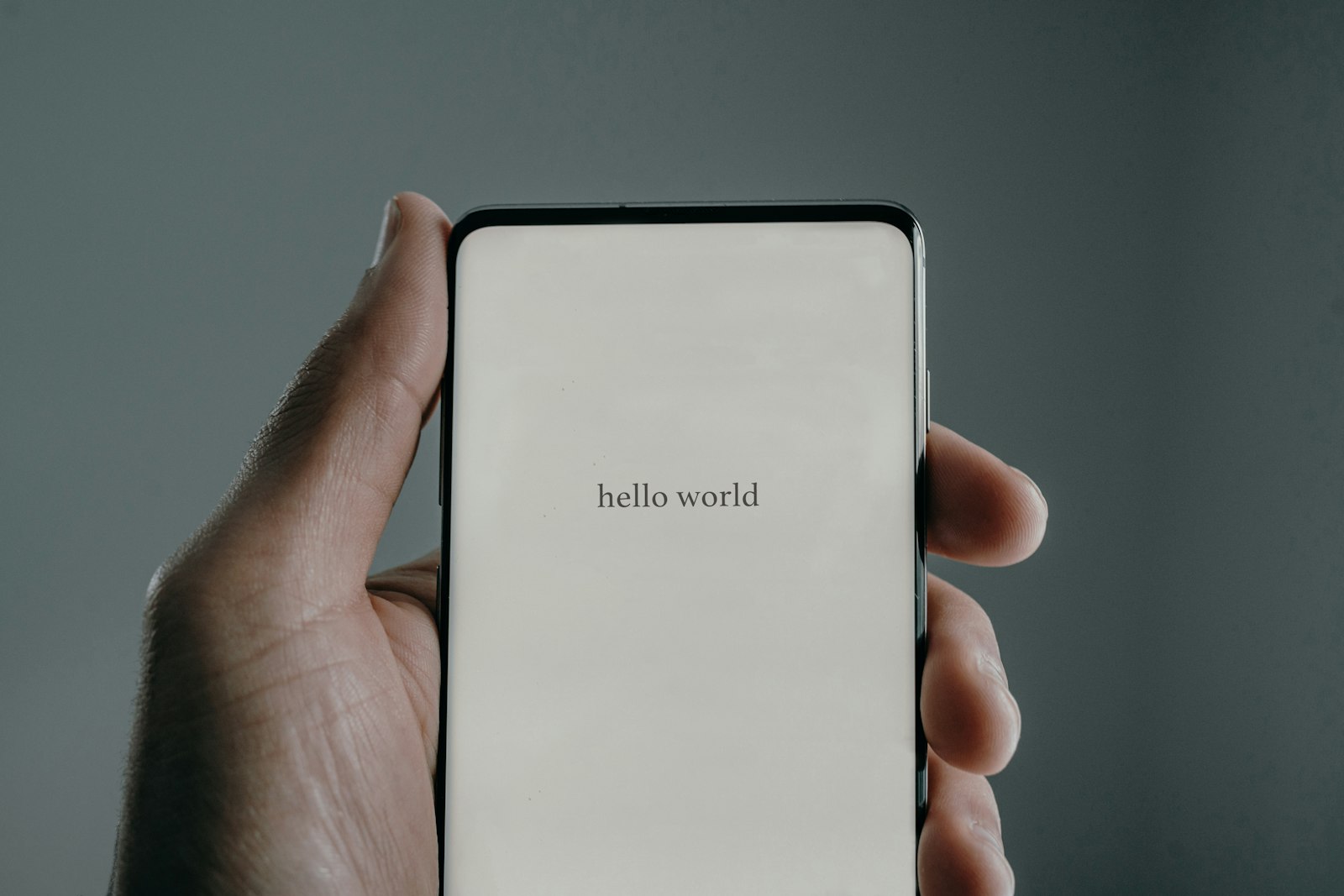 Hand hält ein Smartphone mit leerem Bildschirm