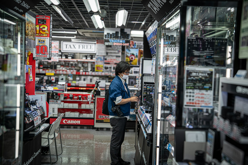 Person stöbert in einem hell erleuchteten Elektronikmarkt