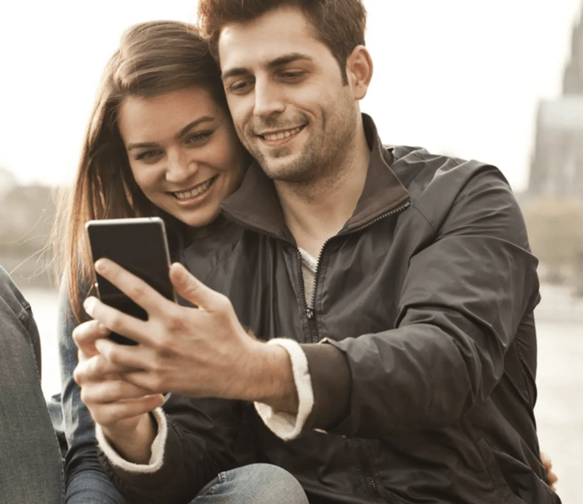 Lächelndes Paar teilt ein Smartphone