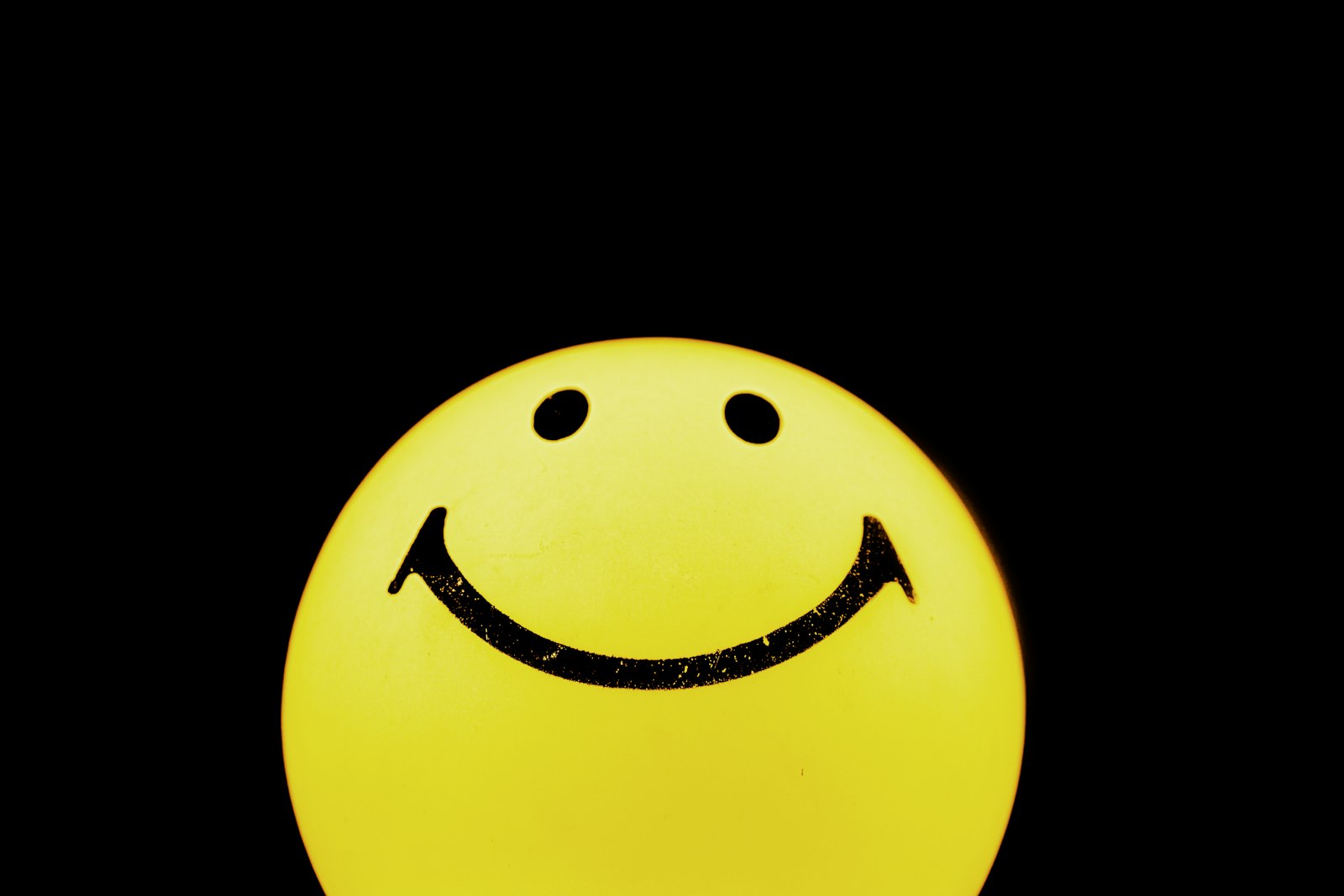 Gelber Smiley vor schwarzem Hintergrund