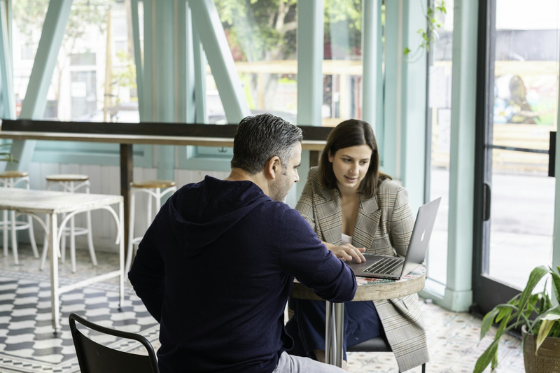 Mann und Frau arbeiten im Café gemeinsam am Laptop