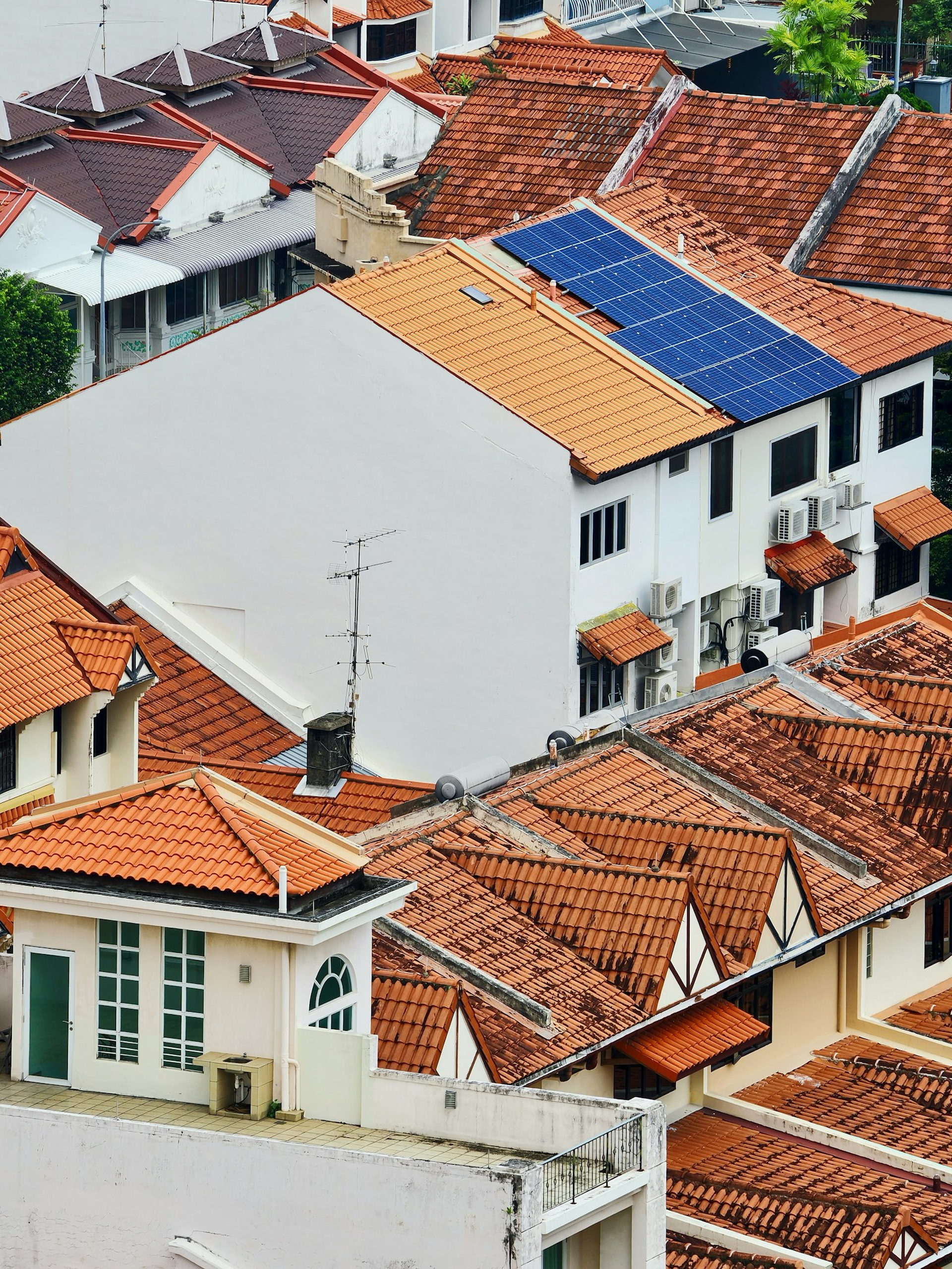 Hausdächer in einem Wohngebiet, eines davon mit Solarmodulen