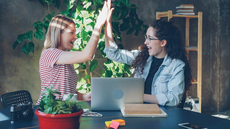 Zwei Frauen feiern einen Erfolg mit High Five