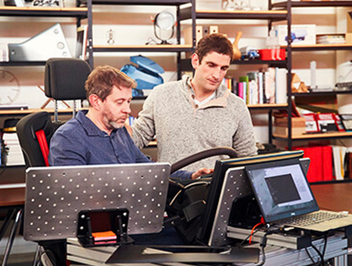 Zwei Techniker beim Prototypentest mit Laptop in der Werkstatt