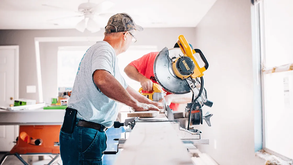 Handwerker arbeitet mit einer Kappsäge in einer hellen Wohnung