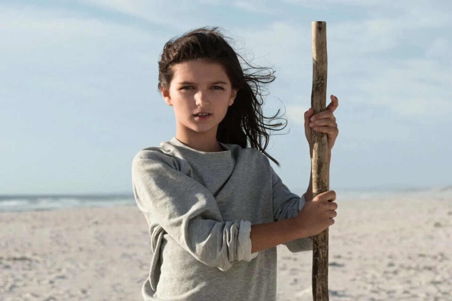 Mädchen mit Wanderstock am Strand