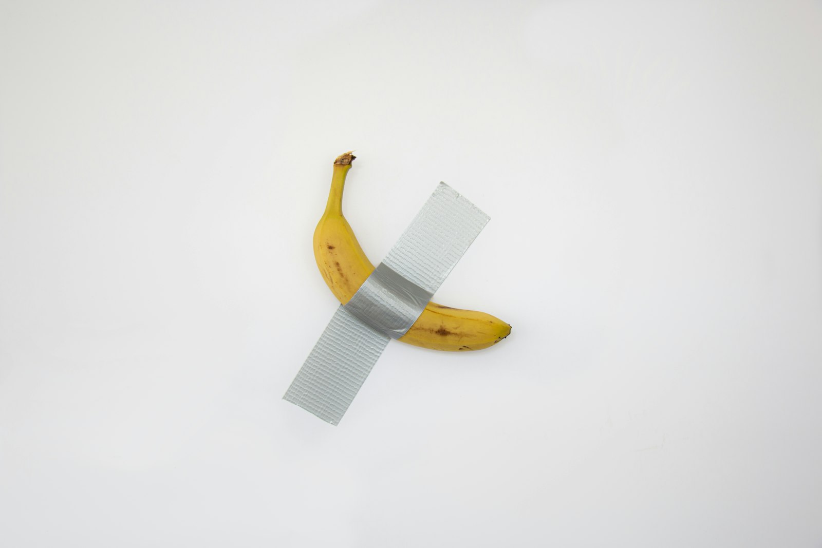 Mit Klebeband an die Wand geklebte Banane