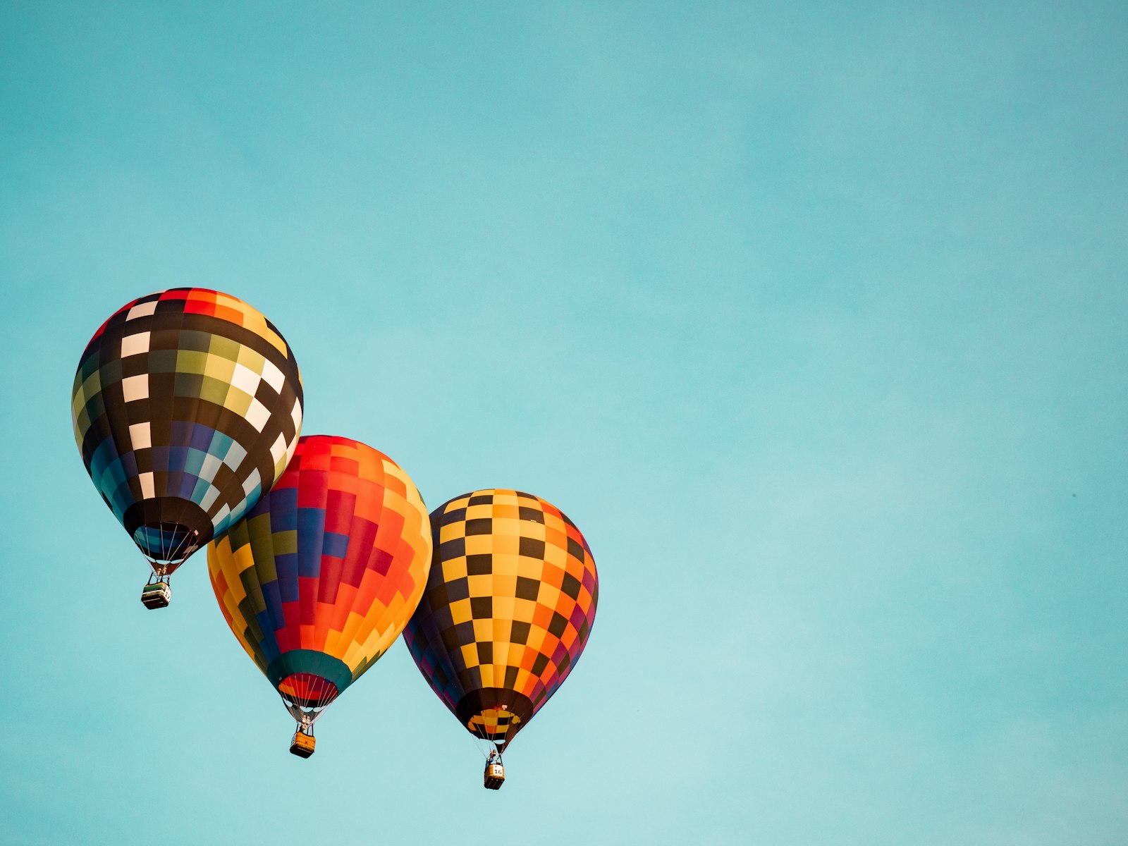 Drei bunte Heißluftballons am blauen Himmel