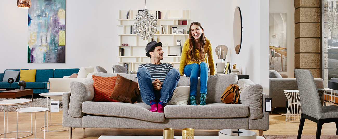 Entspanntes Paar auf modernem Sofa im hellen Wohnzimmer