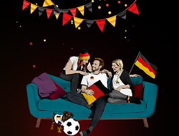 Deutsche Fußballfans auf Sofa mit Fahne, Trikot und Hund