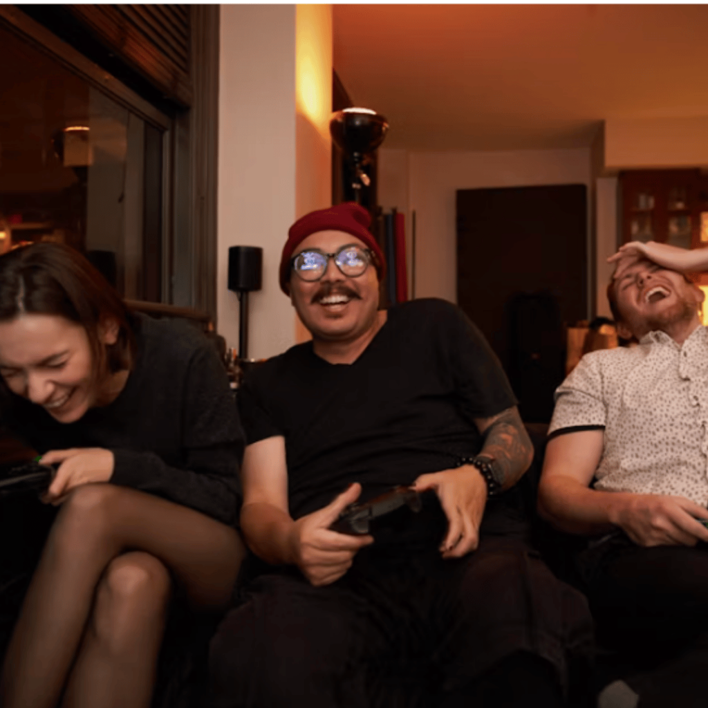 Gamification und Loyalty: Freunde lachen beim Spieleabend mit Controllern