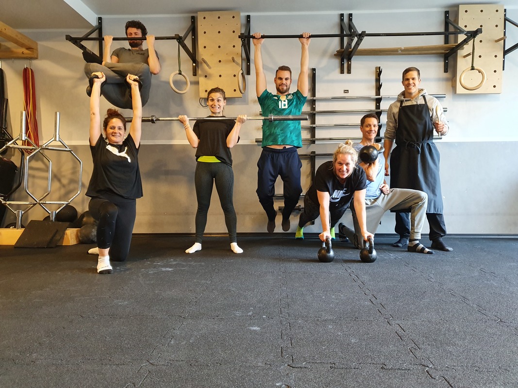Sieben Personen im Functional-Studio beim Gruppenfitness, freundliche Teamatmosphäre, Trainingsgeräte im Hintergrund