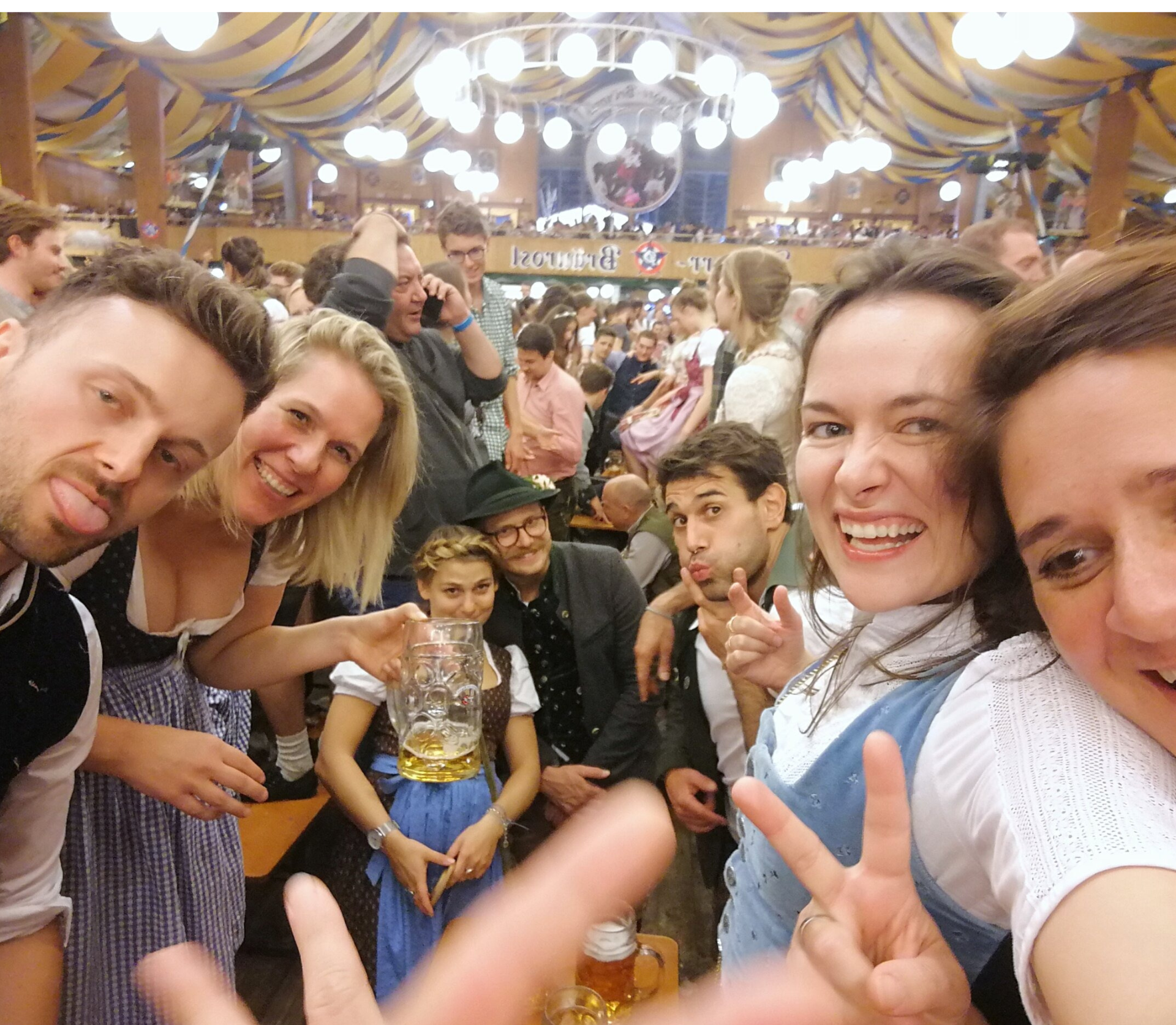 Oktoberfest-Selfie: Freunde im Festzelt mit Bierkrügen und Trachten