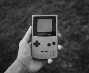 Retro-Handheld-Spielkonsole in Hand, schwarzweiß, nostalgischer Look
