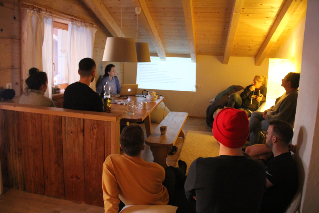 Gemütliche Team-Präsentation im Holzloft mit Beamer und kleiner Gruppe
