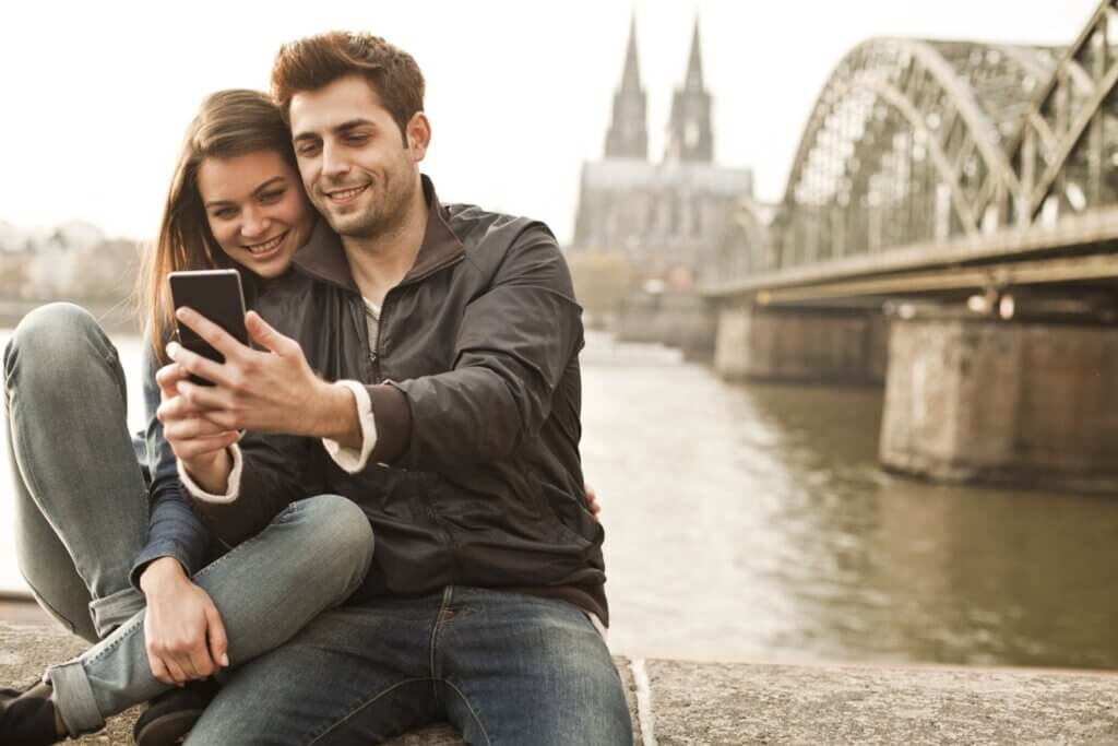 Erfolgreiche Loyalty-App: Paar am Fluss teilt Smartphone