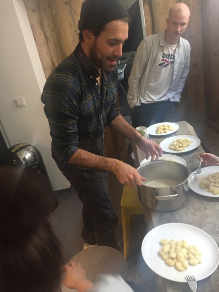 Mann serviert Knödel an Küchentheke, gemütlicher Abend