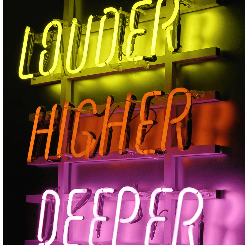 Neon‑Schriftzug „louder higher deeper“ – b2b empfehlungsmarketing