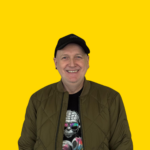 Lächelndes Portrait: Kundenbindung steigern mit sympathischer Person vor gelbem Hintergrund