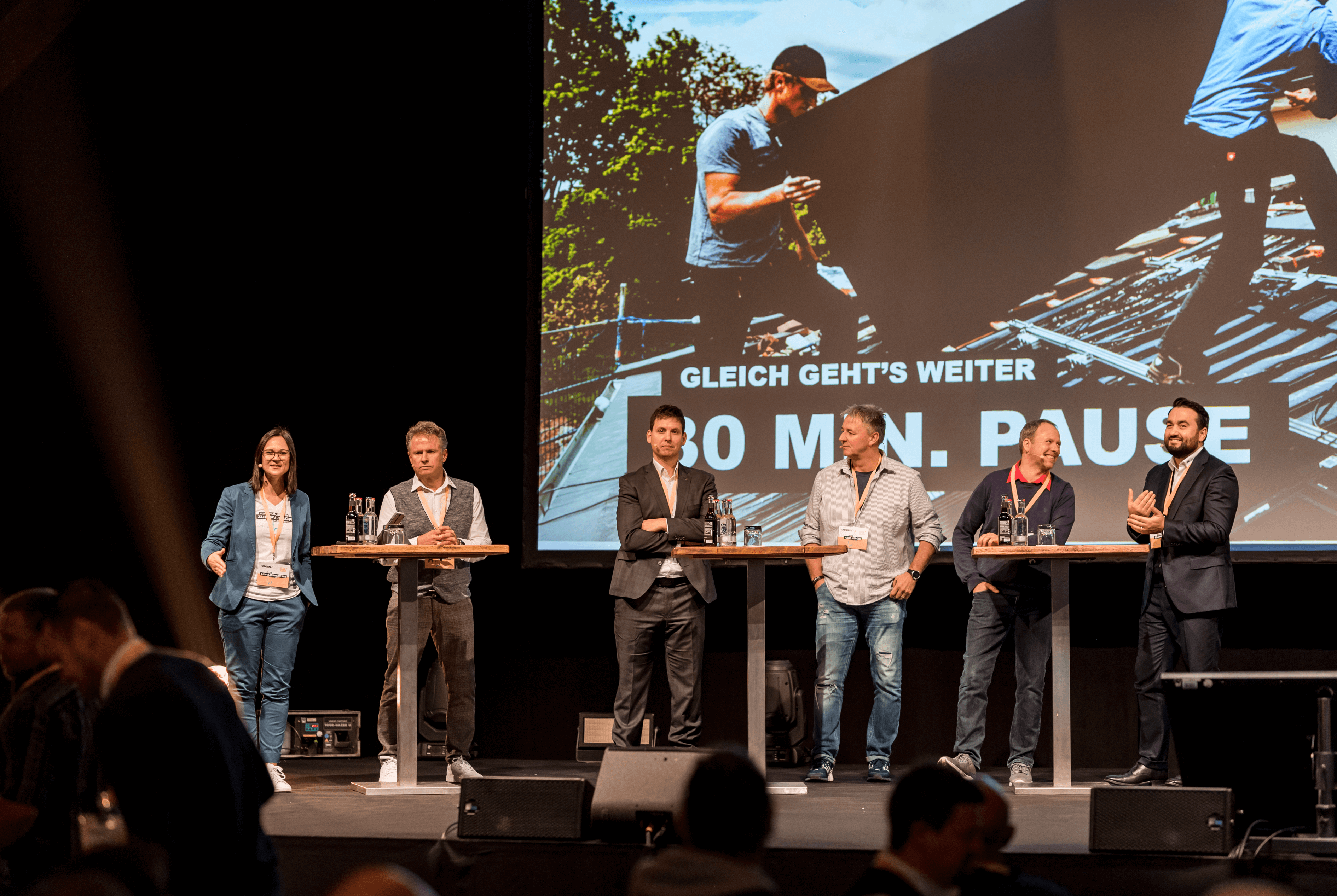 Panel auf Konferenzbühne – Partnerprogramm Photovoltaik für Verarbeiter, 10‑minütige Pause angezeigt.