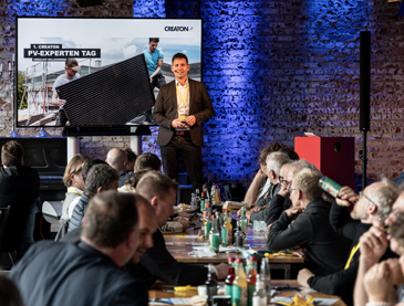 Eine Gruppe von Menschen diskutiert begeistert über Solartechnologie in einem modernen Büro