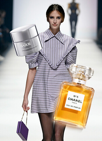 Model auf Catwalk mit Chanel No.5, Kosmetikprodukten und lila Tasche