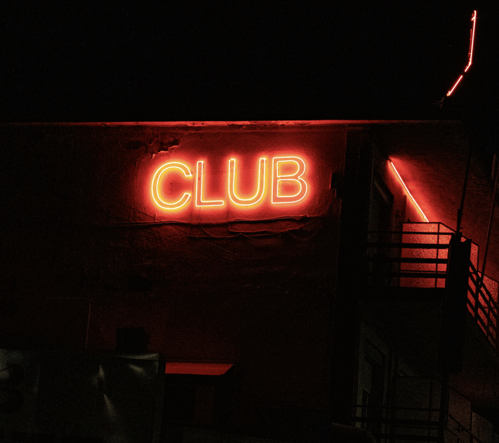 Rotes Neonschild CLUB an Fassade, VIP Club Loyalty Programm, nächtliche Atmosphäre