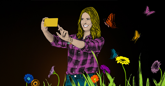 Illustration: Frau macht Selfie mit gelbem Smartphone, umgeben von bunten Blumen und Schmetterlingen