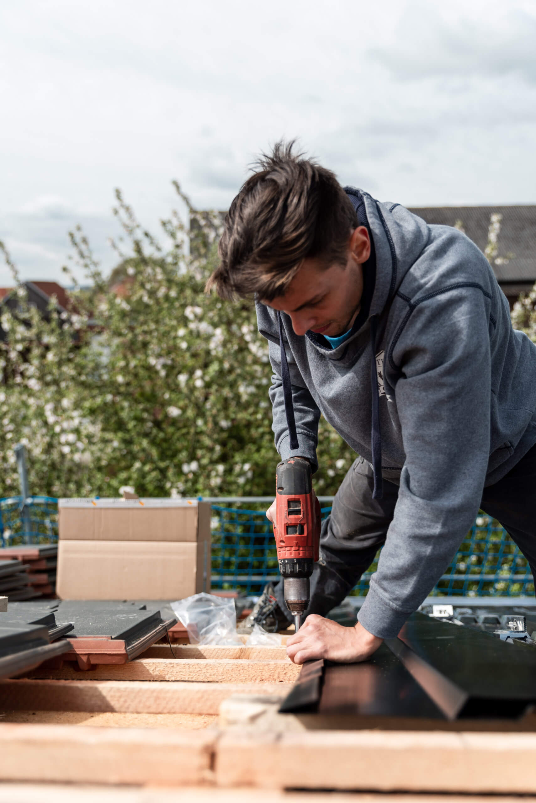 Partnerprogramm Photovoltaik für Verarbeiter: Monteur bohrt Montageelemente im Garten