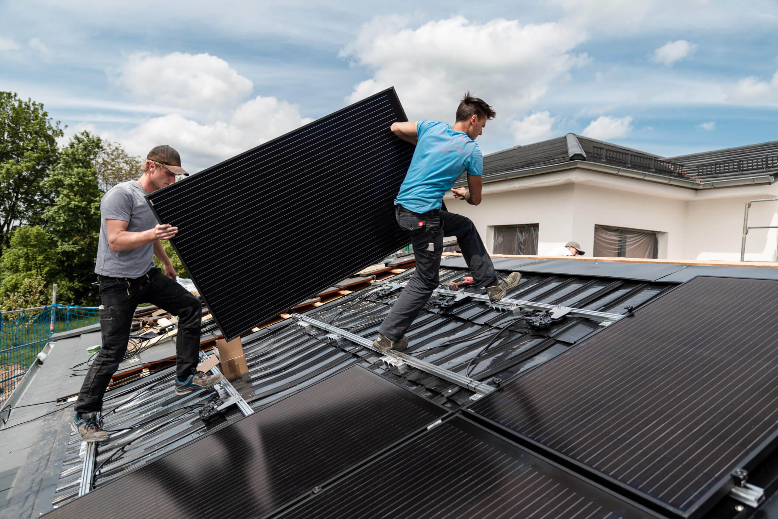 Partnerprogramm Photovoltaik für Verarbeiter: Monteure installieren Solarmodule auf Schrägdach