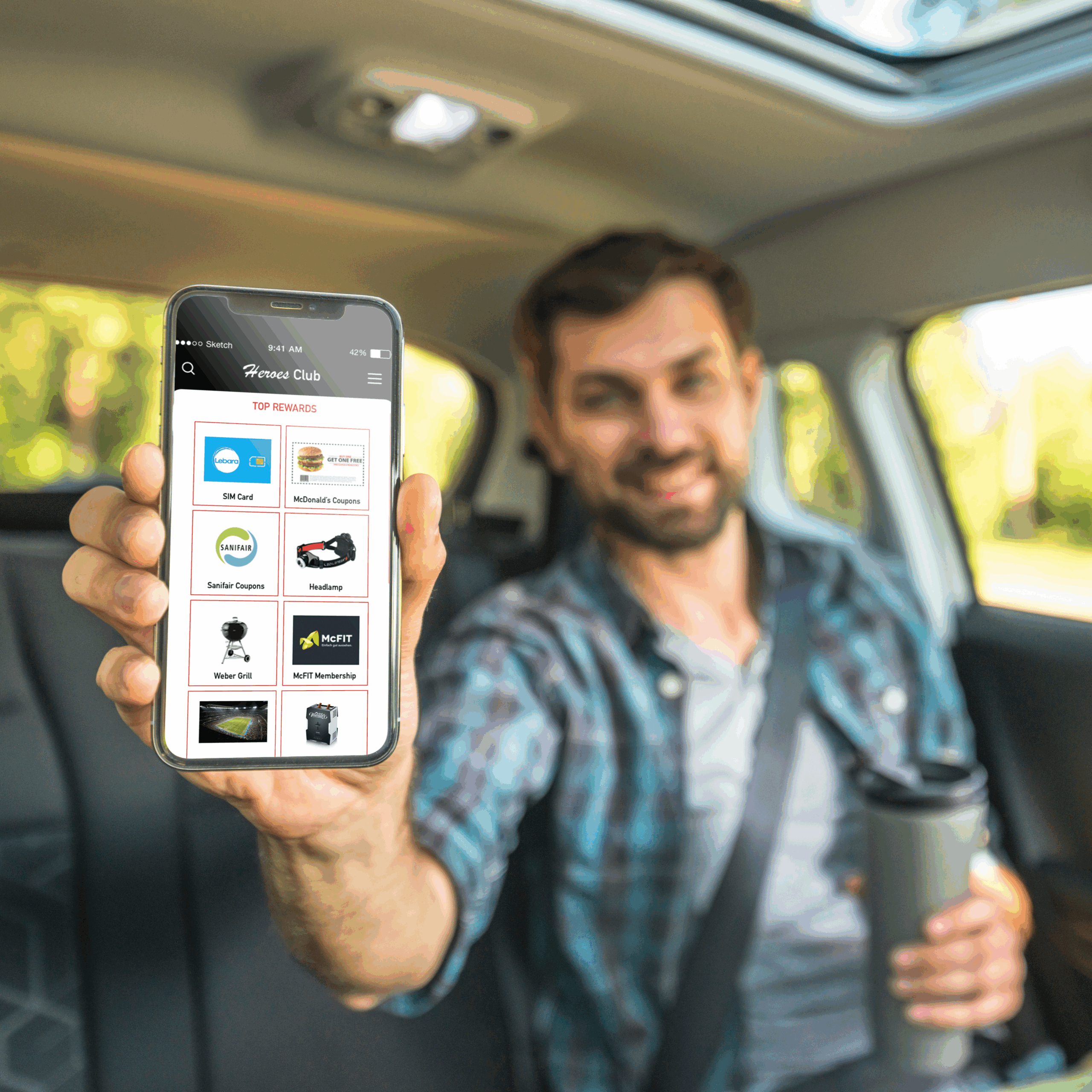 Mann zeigt Smartphone mit Vorteilsprogramm für Lkw‑Fahrer im Auto