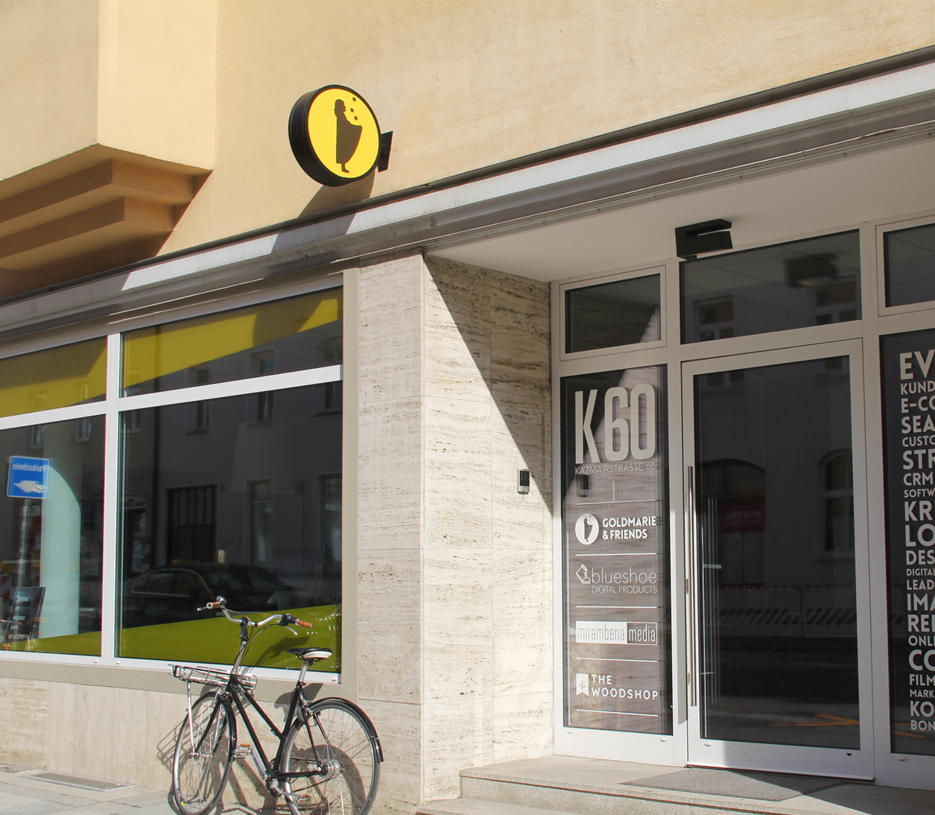 Modernes K80-Ladenlokal mit Glasfassade und gelbem Logo
