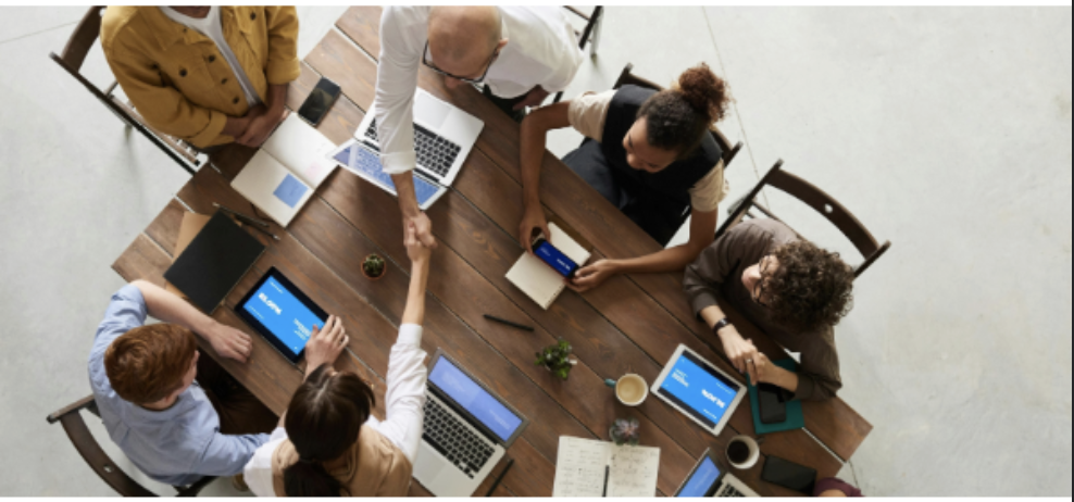 Teammeeting mit Laptops und Tablets, kollaborative Zusammenarbeit am Konferenztisch