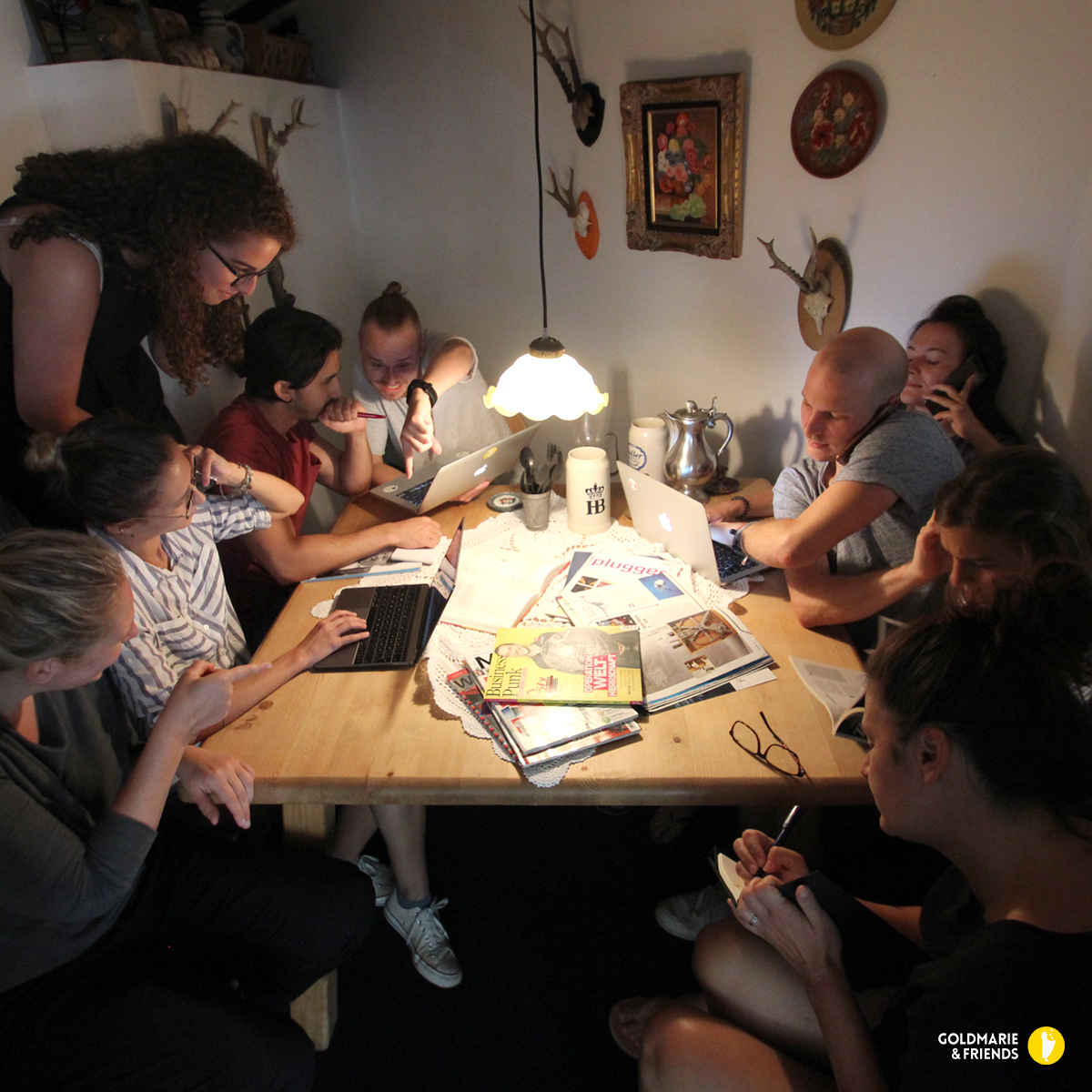 Arbeitsgruppe beim nächtlichen Brainstorming im warmen Lampenschein am Holztisch